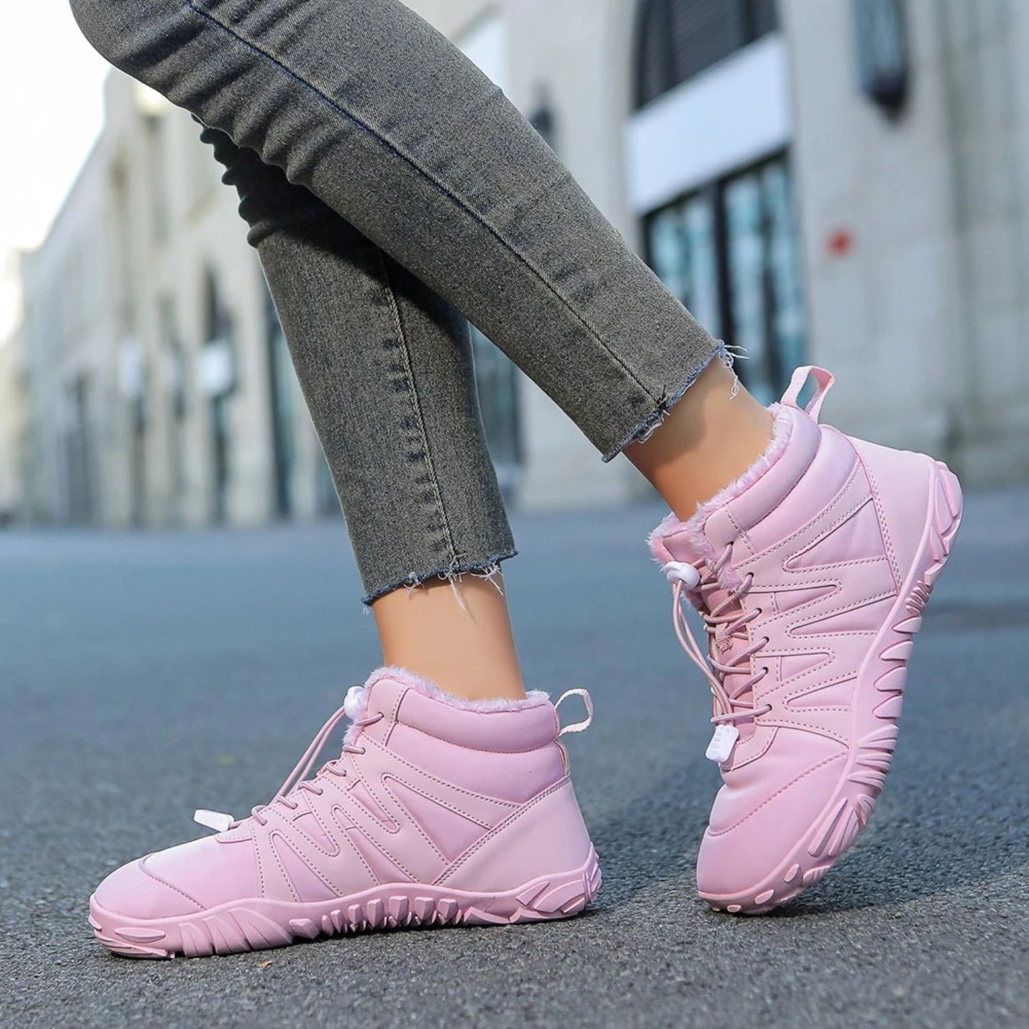 Person wearing pink fleece-lined winter boots with leggings, stepping outdoors.