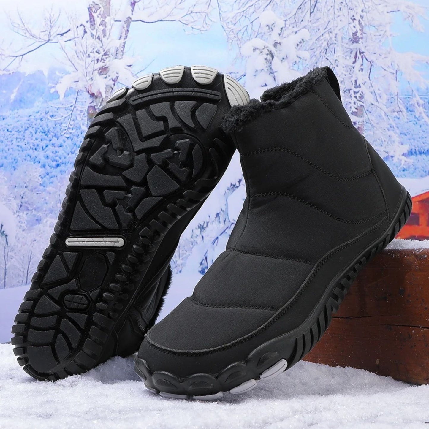 Black winter boots shown in snow with sole facing forward to highlight traction.