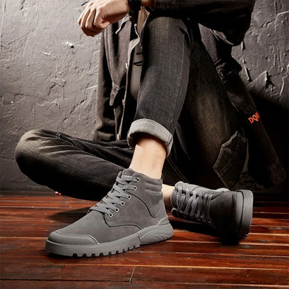Black winter boots worn with cuffed jeans, shown in motion on wood flooring.