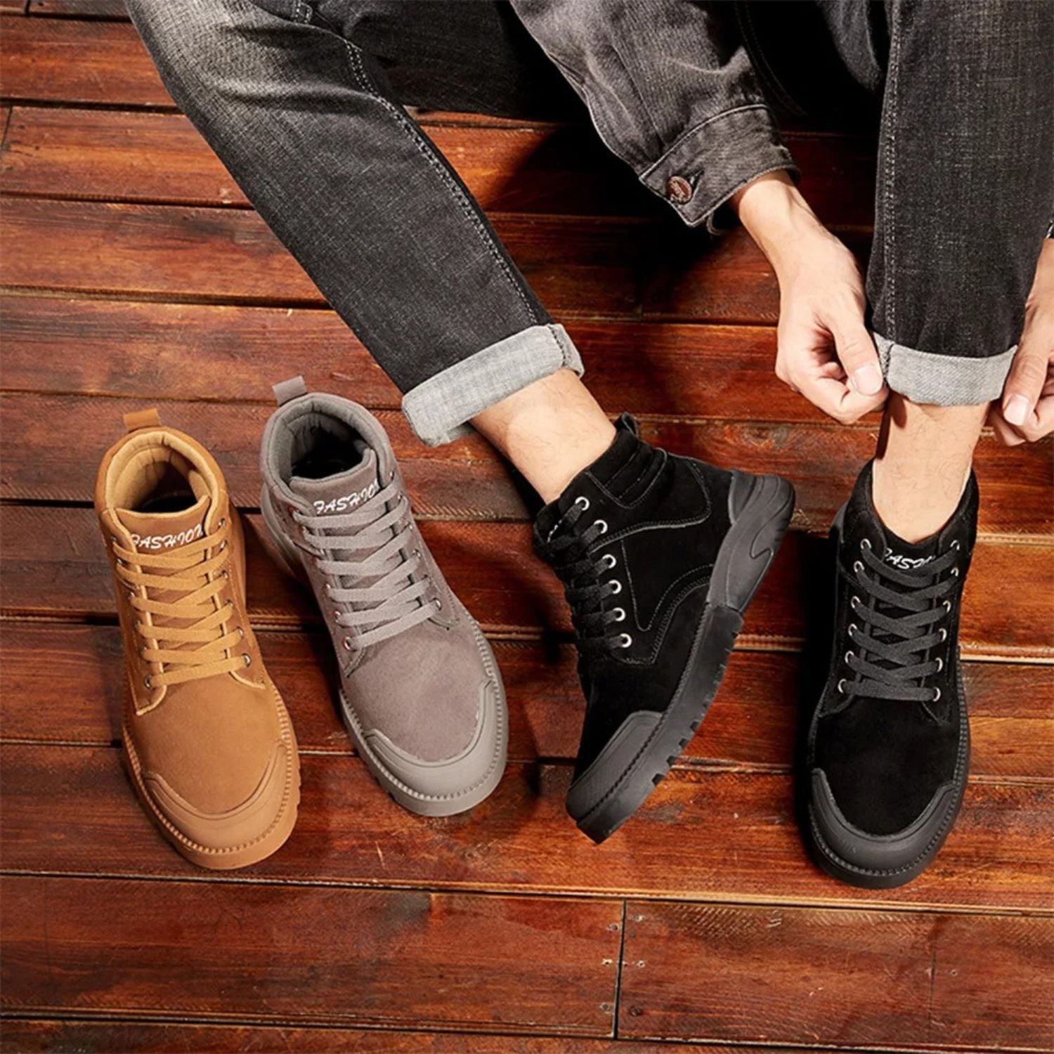 Top view of brown, gray, and black winter boots placed on wooden floor next to legs.
