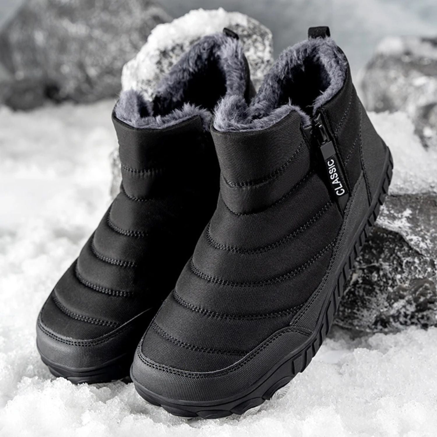 Top view of black winter boots with fleece lining, placed outdoors on snow.
