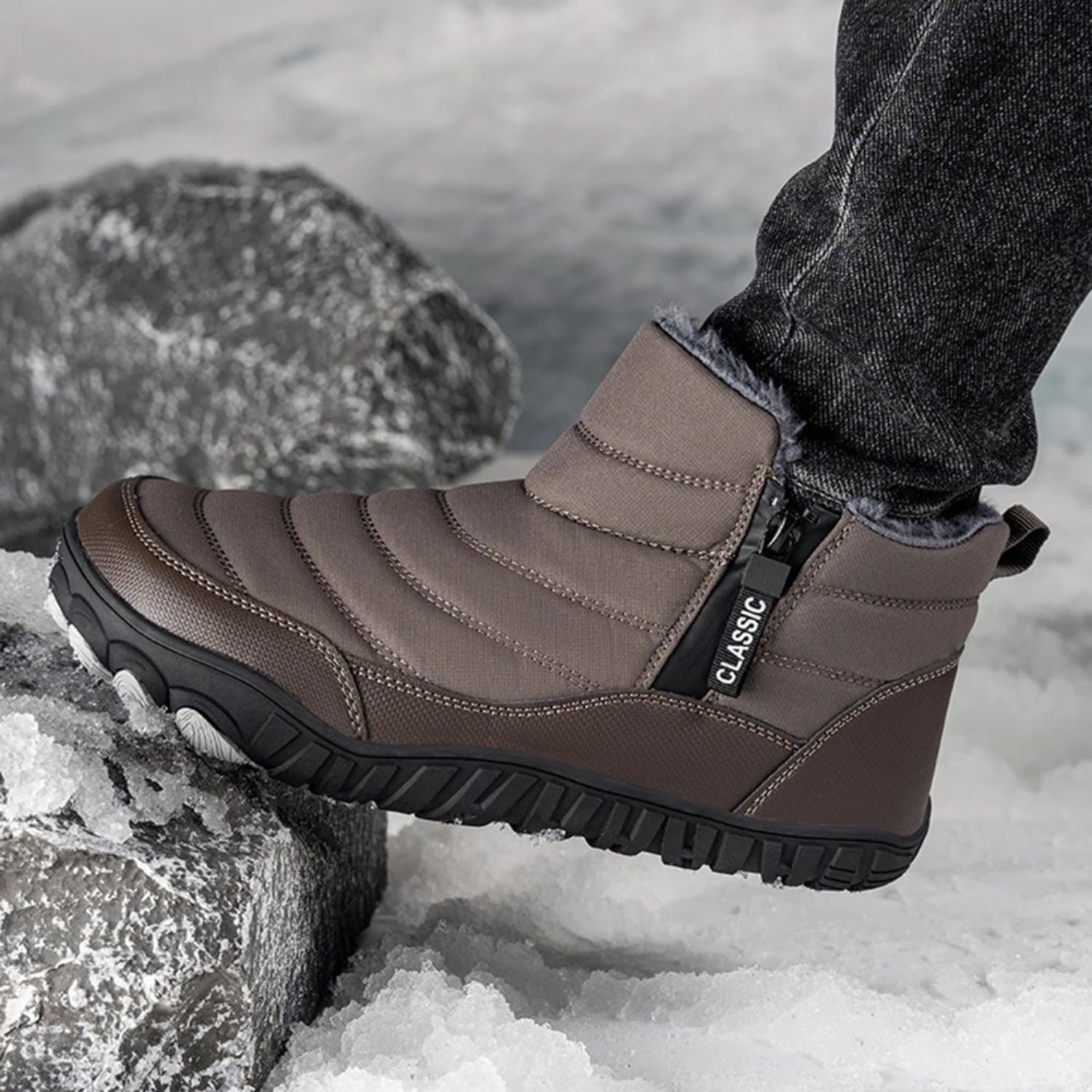 Brown ankle-high winter boots worn in snow, shown with thick socks and side zipper visible.