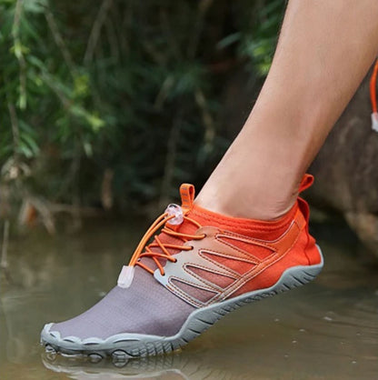 Two people wearing pink and lavender water shoes, sitting on a rock outdoors.