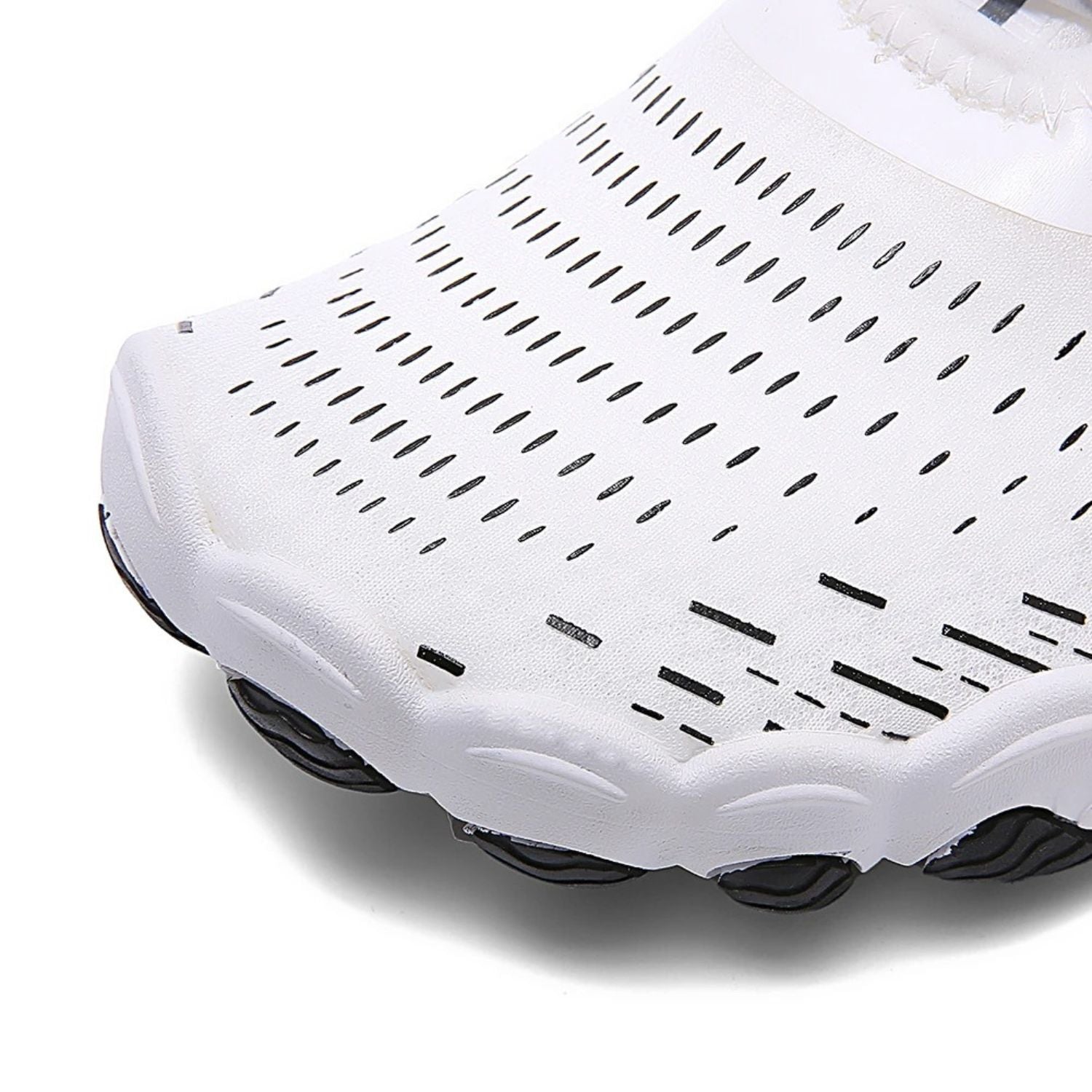 Close-up of toe area on white barefoot shoe showing ventilation holes and grip.