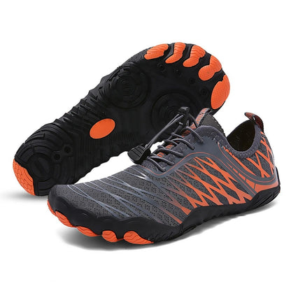 Black barefoot shoe with orange traction pods and breathable mesh upper, shown from side and sole.