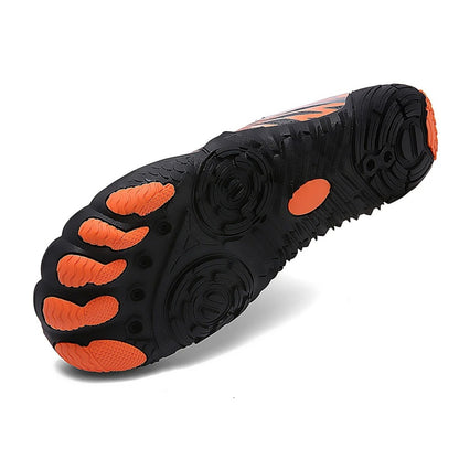 Outsole of black barefoot shoe showing orange circular grip patterns.