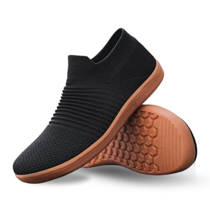 Black knit slip-on shoe with contrasting brown textured sole, angled side view.