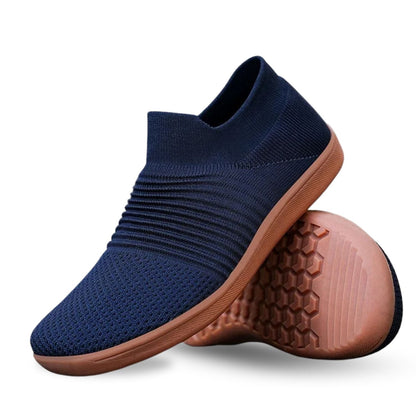 Navy blue knit slip-on sneaker with ribbed upper and brown cushioned sole.