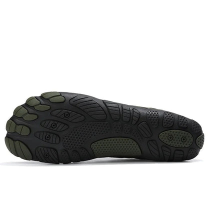 Bottom view of black water shoe outsole with green anti-slip tread pattern.